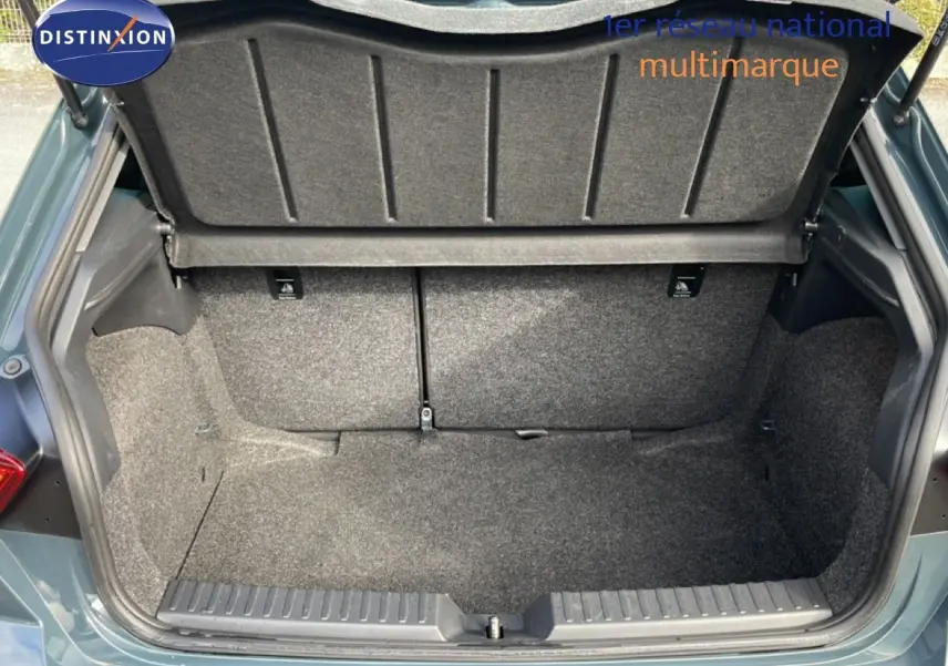 Coffre ouvert vu de l'arrière d'une SEAT Ibiza bleu Fjord, montrant un espace de rangement propre et tapissé.