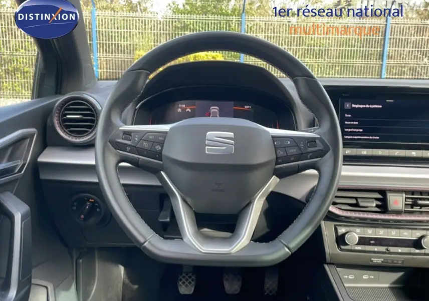Vue intérieure centrée sur le volant noir de la SEAT Ibiza 2025, avec tableau de bord digital et console moderne visible.
