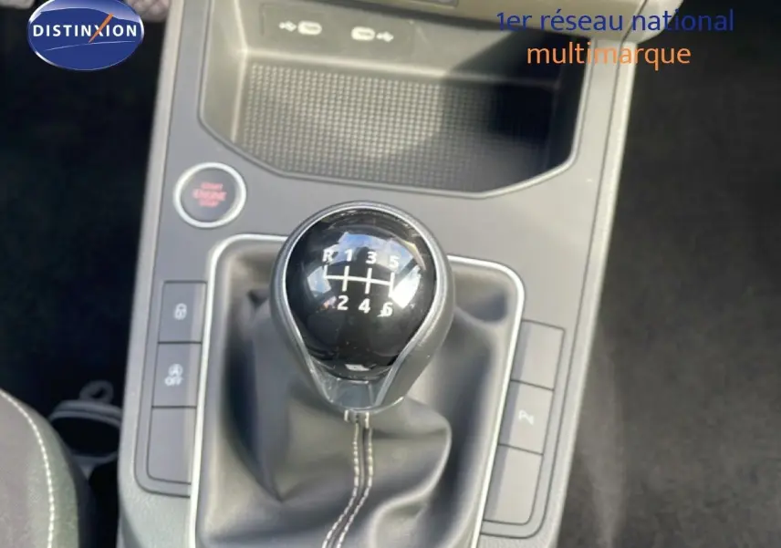 Gros plan sur le levier de vitesses manuel noir de la SEAT Ibiza 2025, entouré de commandes et console grise.