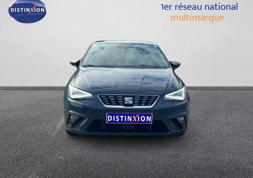 Vue frontale d'une SEAT Ibiza 2025 bleu fjord avec phares LED allumés sur fond neutre.