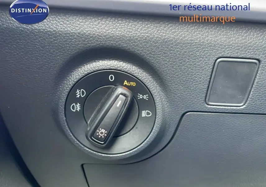 Gros plan sur le sélecteur de phares noir du tableau de bord d'une SEAT Ibiza bleu fjord, version 2025.