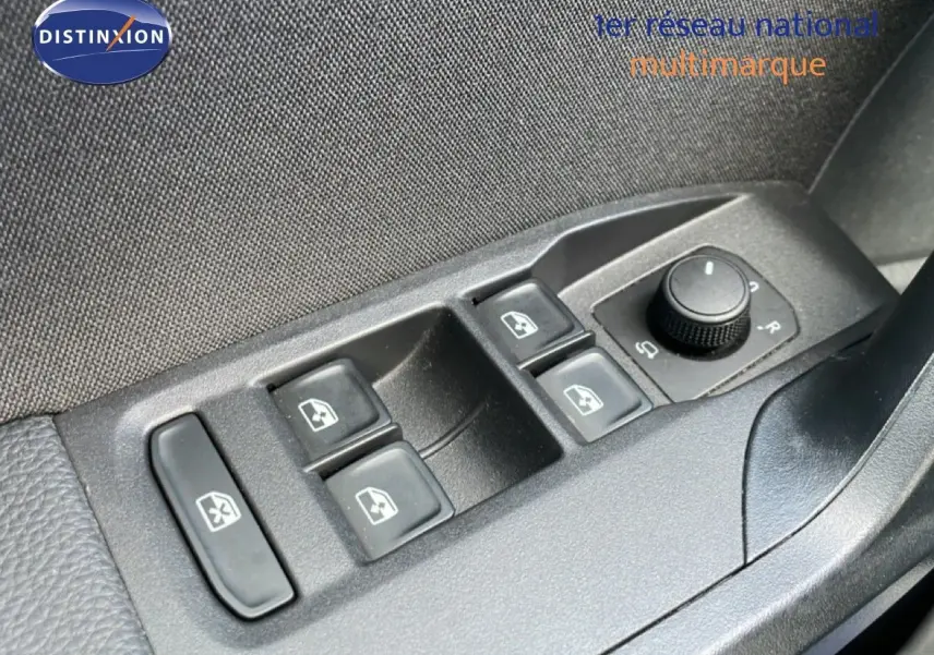 Gros plan sur les commandes des vitres et rétroviseurs côté conducteur d'une SEAT Ibiza bleu Fjord 2025.