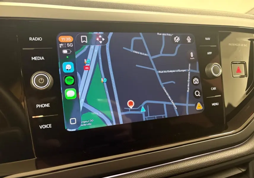 Écran tactile central du Volkswagen Taigo 2024 affichant une carte de navigation avec commandes latérales.