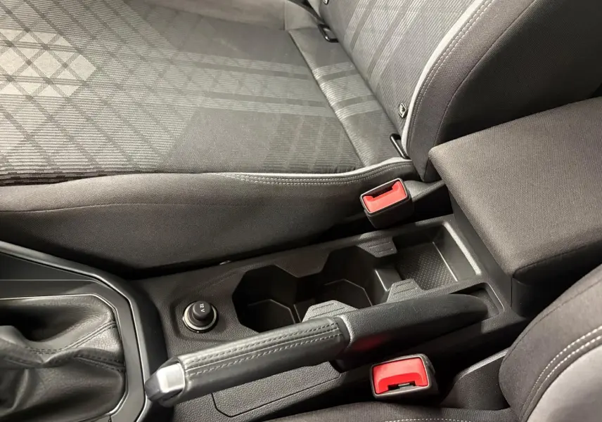 Vue rapprochée de la console centrale et des sièges avant gris foncé du Volkswagen Taigo 2024, version R-Line.