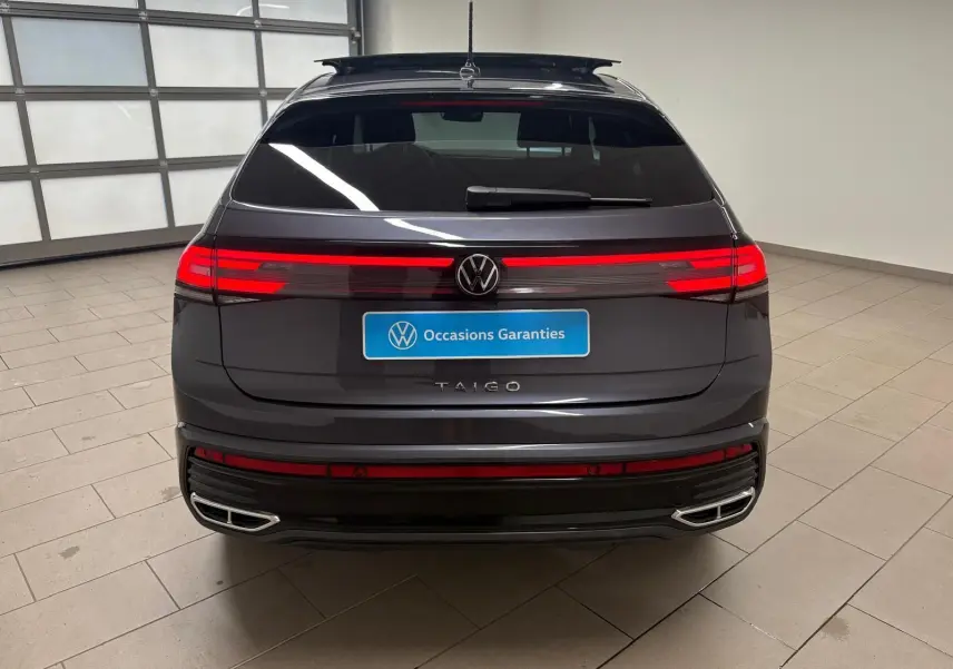 Vue arrière d'un Volkswagen Taigo gris cendré 2024 avec feux LED continus et double sortie d'échappement chromée.