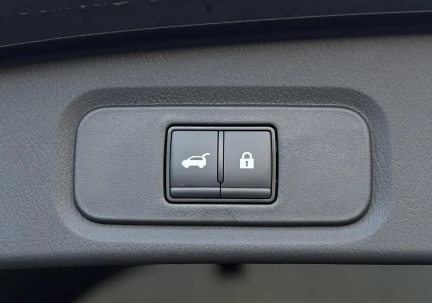 Gros plan sur les boutons d'ouverture électrique du hayon et de verrouillage du Nissan Qashqai gris Ceramic 2025.