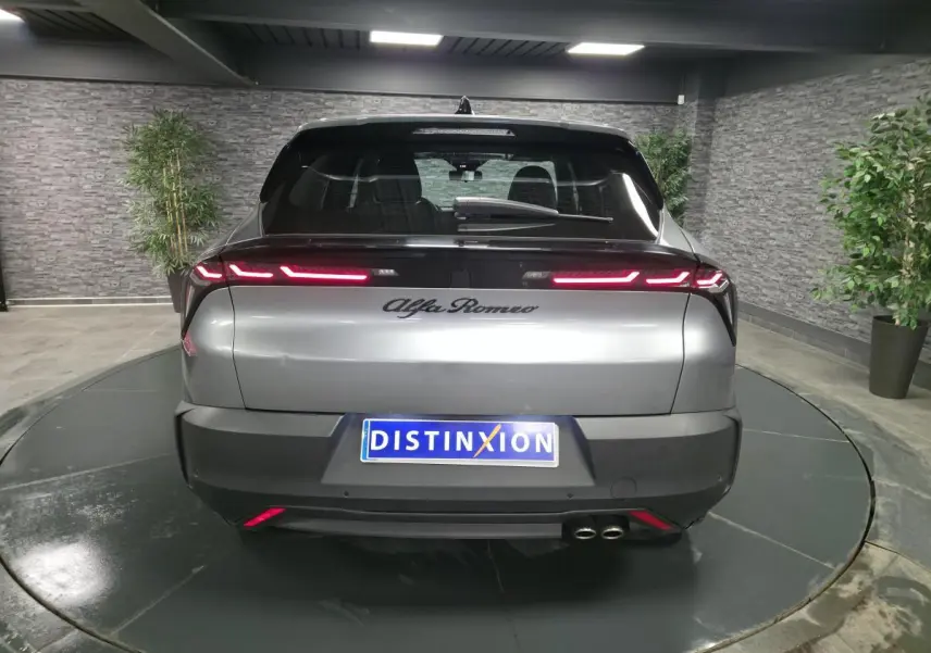 Vue arrière d'une Alfa Romeo Junior 1.2 hybride gris métallisé avec feux arrière LED et double sortie d'échappement.