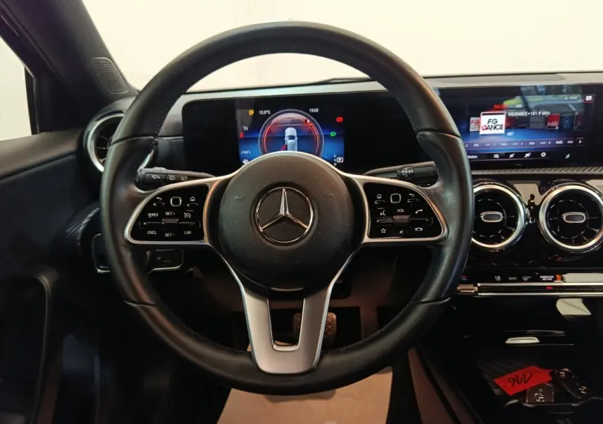 Vue intérieure centrée sur le volant cuir noir de la Mercedes Classe A 200 Business Line avec tableau de bord numérique.