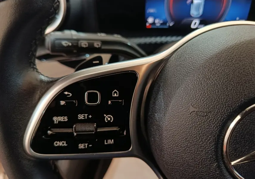 Gros plan sur le volant cuir noir de la Mercedes Classe A 200 Business Line 2021, avec commandes multifonctions intégrées.