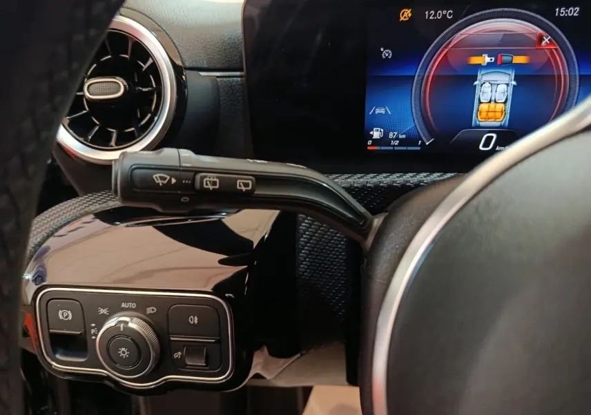 Vue rapprochée du tableau de bord noir de la Mercedes Classe A 200 Business Line, avec écran digital et commandes éclairage.