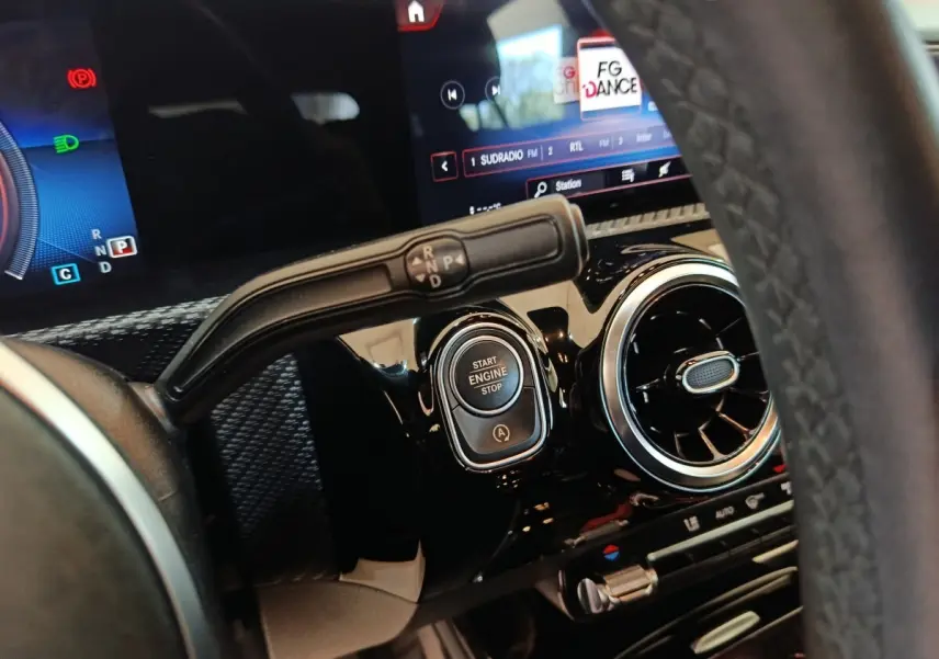 Gros plan intérieur sur le tableau de bord noir de la Mercedes Classe A 200, avec bouton start/stop et levier de vitesses.