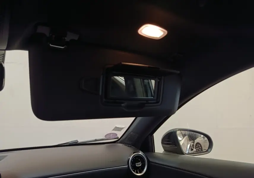 Intérieur noir de la Mercedes Classe A 200 Business Line 2021, vue côté droit avec pare-soleil et miroir éclairé.