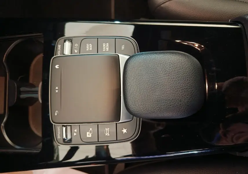 Vue rapprochée du pavé tactile central noir et des commandes multimédias de la Mercedes Classe A A 200 Business Line 2021.