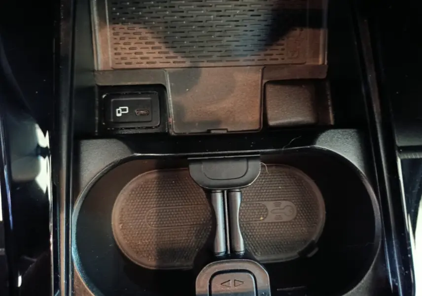 Vue plongeante sur la console centrale noire de la Mercedes Classe A 200 Business Line avec chargeur sans fil et port USB-C.