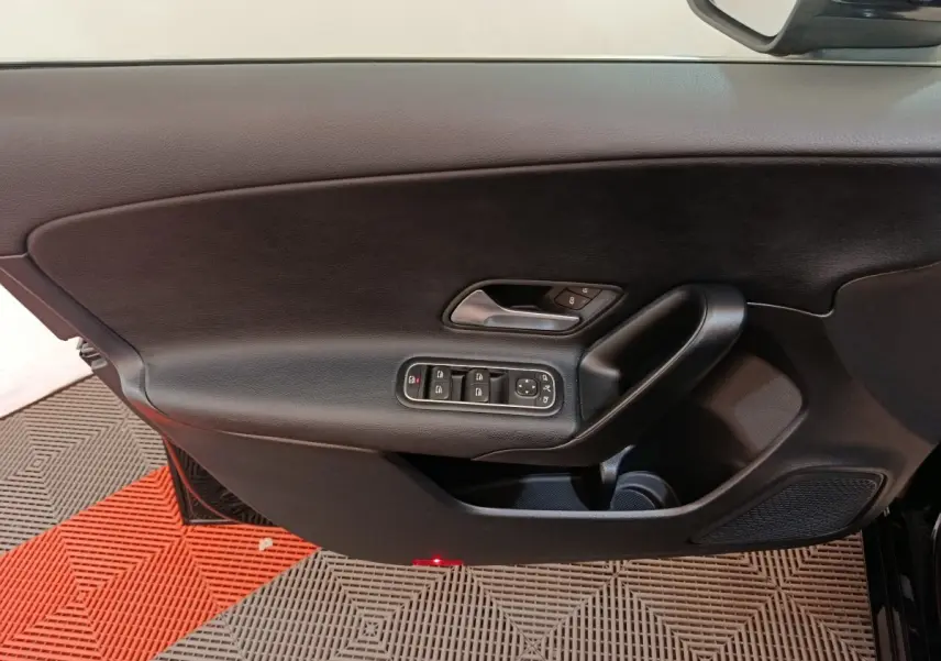 Vue rapprochée de la porte intérieure côté gauche noire de la Mercedes Classe A 200 Business Line avec commandes électriques.