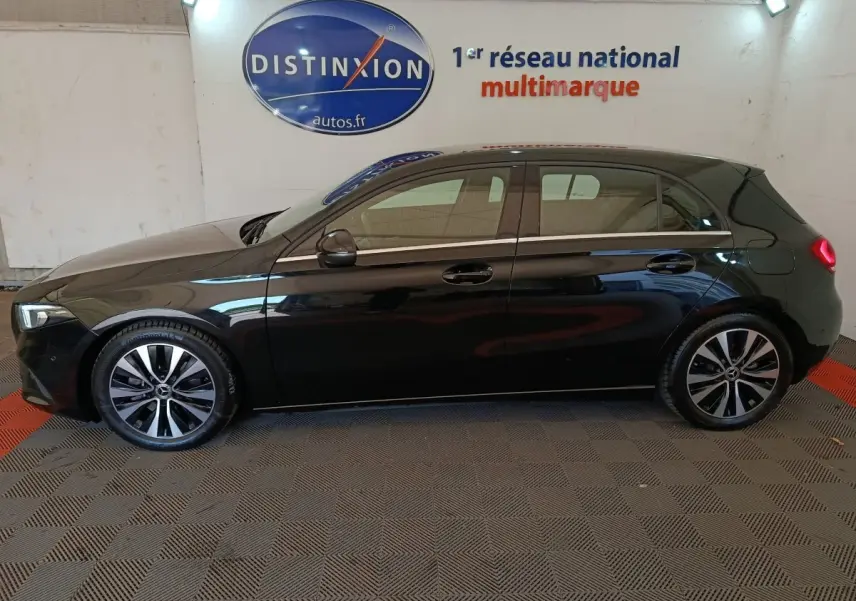 Vue de profil côté gauche d'une Mercedes Classe A A 200 Business Line noire, avec jantes alliage et feux arrière allumés.