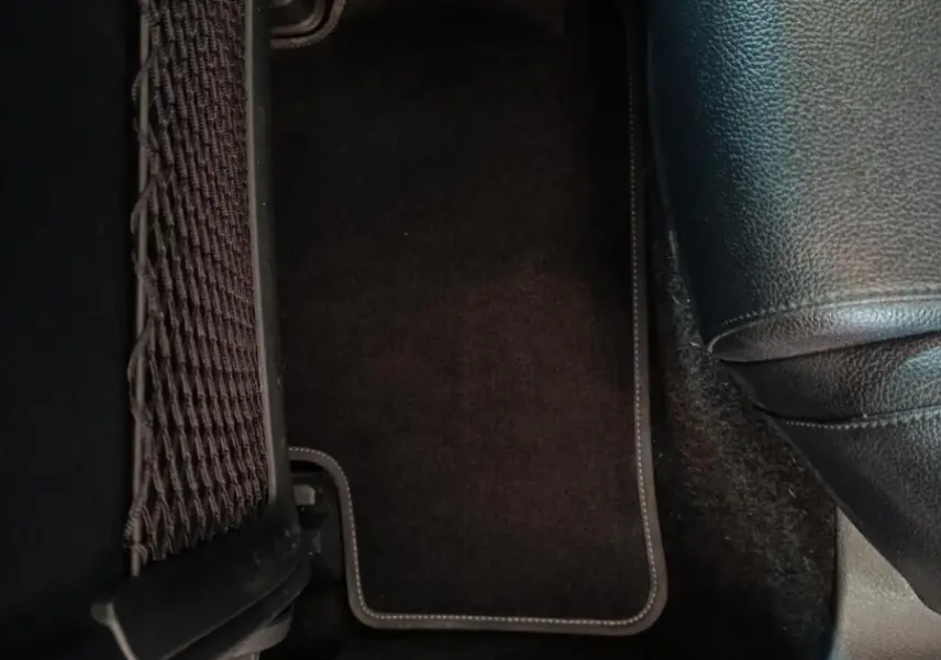 Détail du tapis de sol noir côté droit arrière avec partie de siège en cuir noir d’une Mercedes Classe A 200 Business Line 2021.