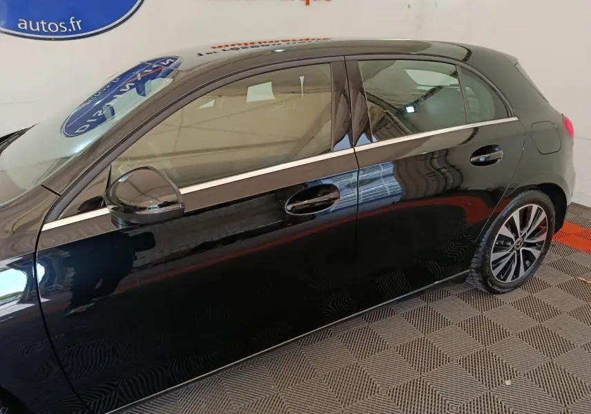 Vue latérale gauche d'une Mercedes Classe A 200 Business Line noire, avec jantes alliage et ligne chromée sur les portières.