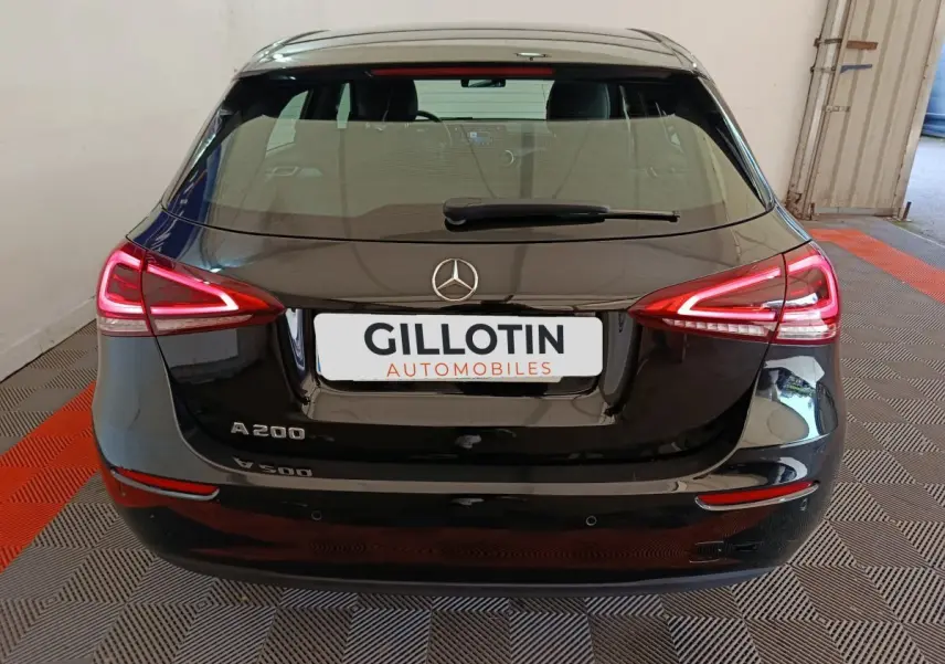 Vue arrière d'une Mercedes Classe A 200 Business Line noire avec feux LED allumés dans un garage.