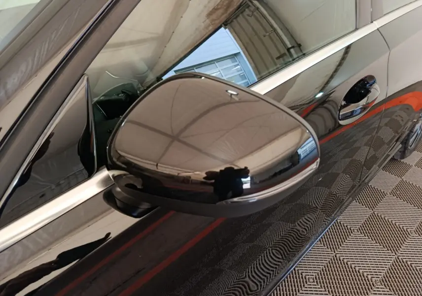 Gros plan sur le rétroviseur côté gauche d'une Mercedes Classe A 200 Business Line noire, reflet du plafond visible.