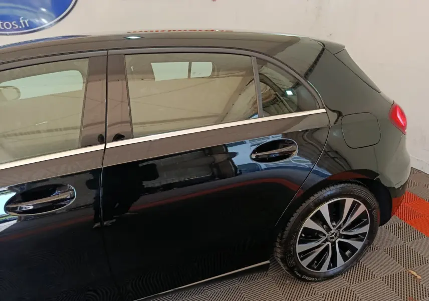 Vue latérale droite d'une Mercedes Classe A 200 Business Line noire, mettant en valeur les jantes alliage et le spoiler de toit.