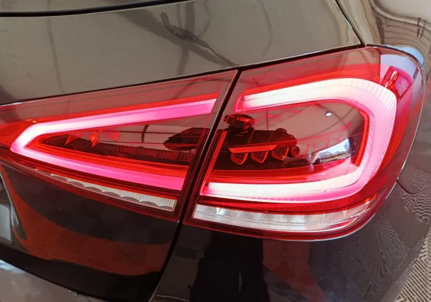 Gros plan sur le feu arrière droit rouge allumé d’une Mercedes Classe A noire, version A 200 Business Line.