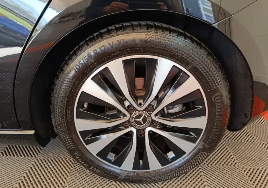 Gros plan sur la roue avant gauche de la Mercedes Classe A noire, mettant en valeur la jante alliage bicolore et le pneu Continental.