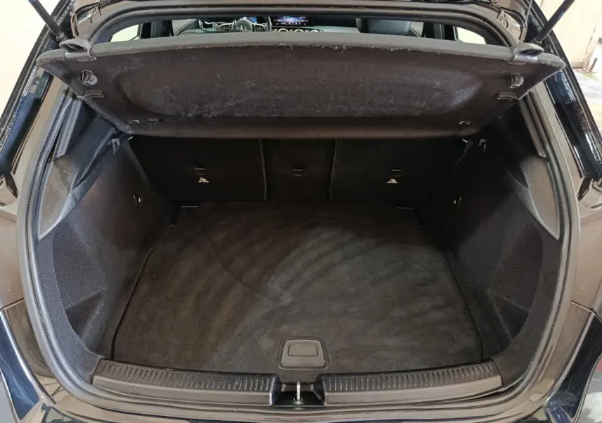 Coffre ouvert vu de l'arrière d'une Mercedes Classe A 200 Business Line noire, espace de chargement vide et propre.