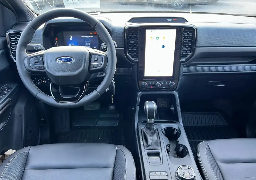 Vue intérieure frontale du Ford Ranger 2025 noir agate, montrant volant cuir multifonctions et écran tactile vertical.