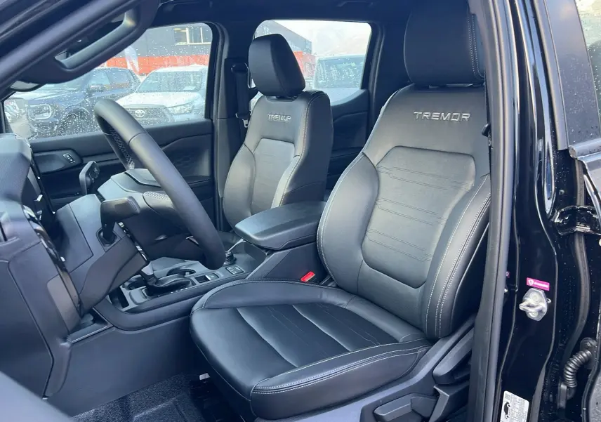 Vue intérieure côté conducteur du Ford Ranger Tremor 2025 noir agate, sièges en cuir avec logo Tremor brodé.