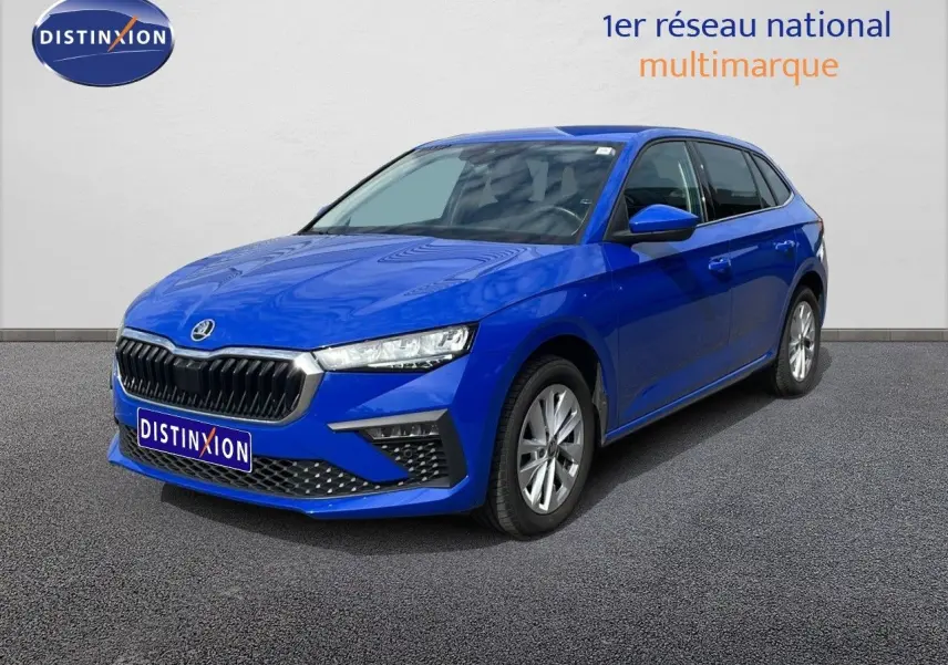 SKODA SCALA bleu racing metal en 3/4 avant droit, mettant en valeur sa calandre noire et ses phares LED fins.