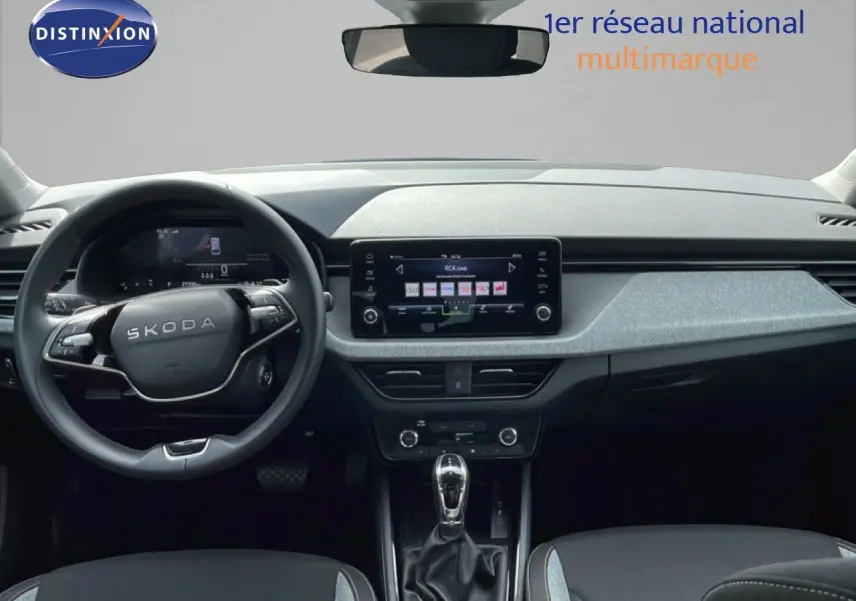 Vue intérieure avant du Skoda Scala 2025, tableau de bord moderne avec écran tactile central et volant multifonction noir.