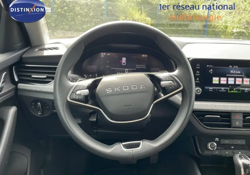 Vue intérieure centrée sur le volant SKODA de la Scala 2025, avec tableau de bord numérique et écran tactile multimédia.