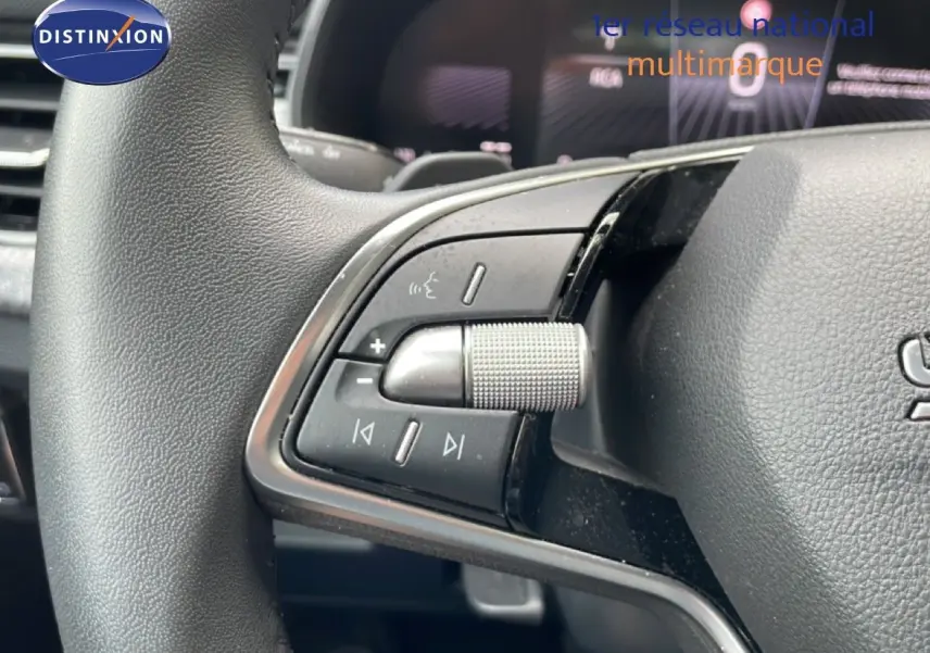 Gros plan sur les commandes multimédia au volant d’une Skoda Scala 2025, finition tissu noir.