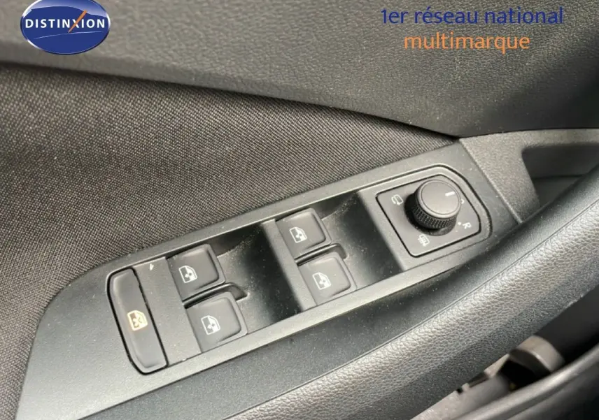 Gros plan sur les commandes de lève-vitres et réglage des rétroviseurs côté conducteur d’une Skoda Scala bleu Racing Metal.
