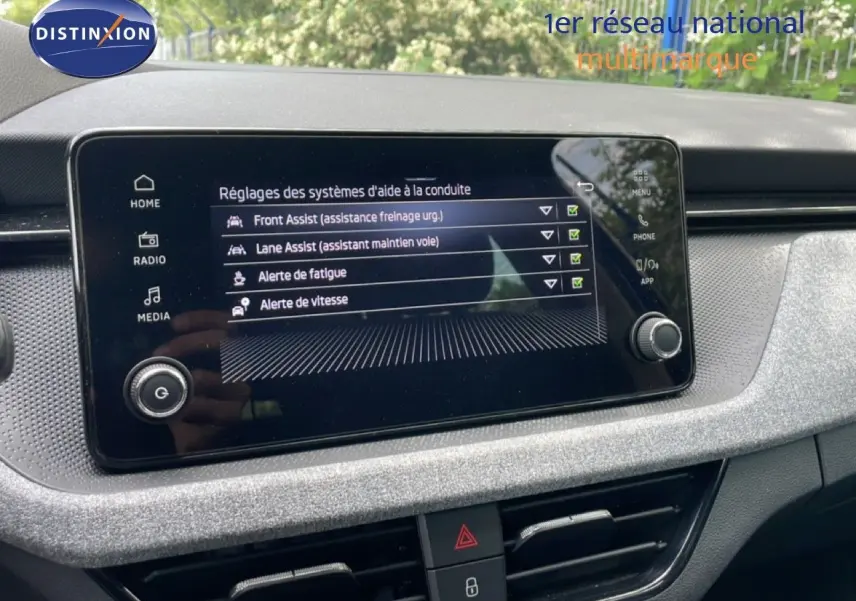 Écran tactile central affichant les réglages d’aides à la conduite dans l’habitacle gris noir d’une Skoda Scala 2025.