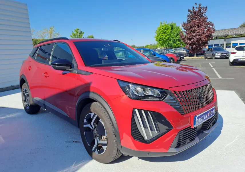 Peugeot 2008 rouge Elixir vue 3/4 avant droit, avec calandre distinctive et feux LED verticaux marquants.