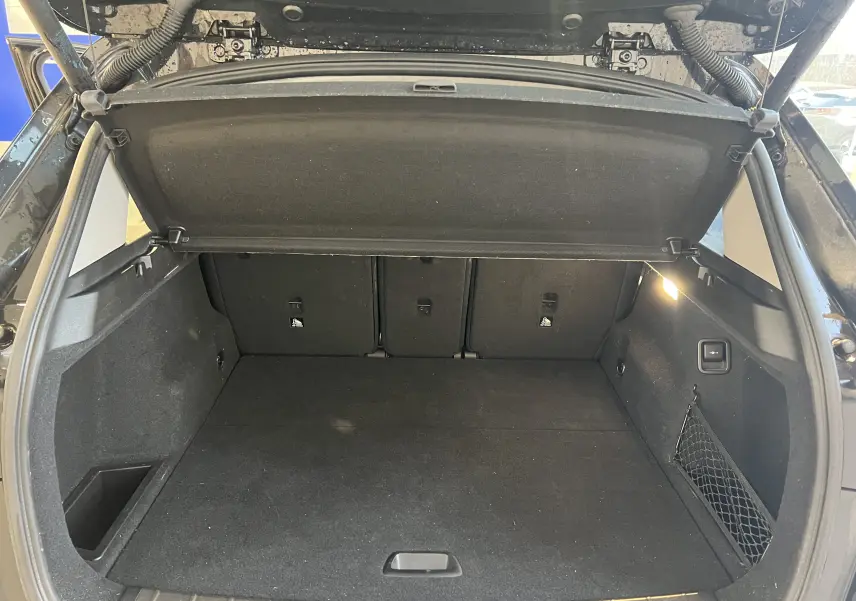 Coffre ouvert d'un BMW X1 F48 Saphirschwarz 2017, montrant un espace de chargement propre et bien éclairé.