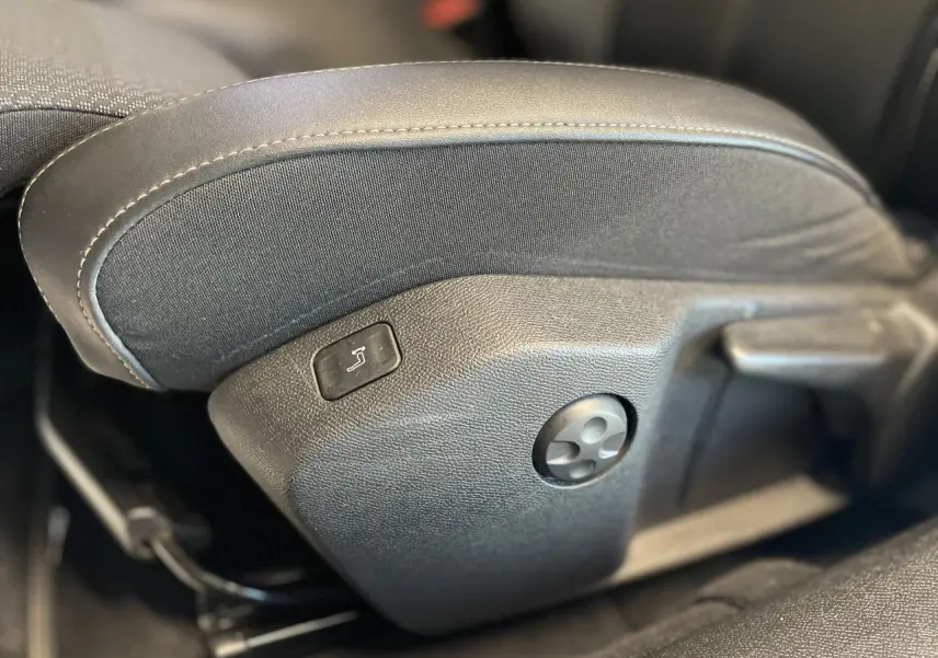 Gros plan sur les commandes latérales du siège avant en cuir noir de la Peugeot 508 SW 2021.