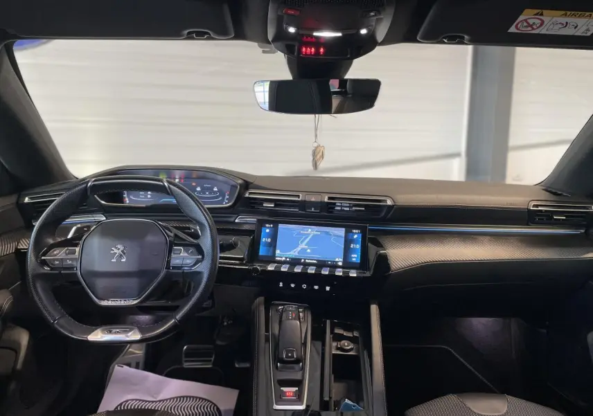 Vue intérieure avant du Peugeot 508 SW 2021 avec tableau de bord noir, écran tactile et volant compact au logo lion.