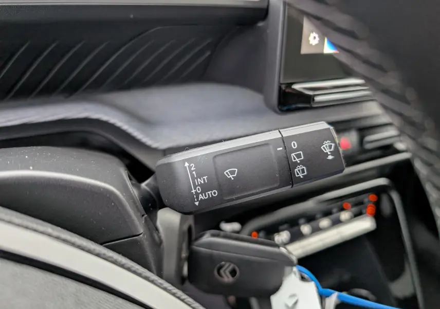 Gros plan sur la commande des essuie-glaces à gauche du volant dans l'habitacle du Citroën C3 Aircross 2025.