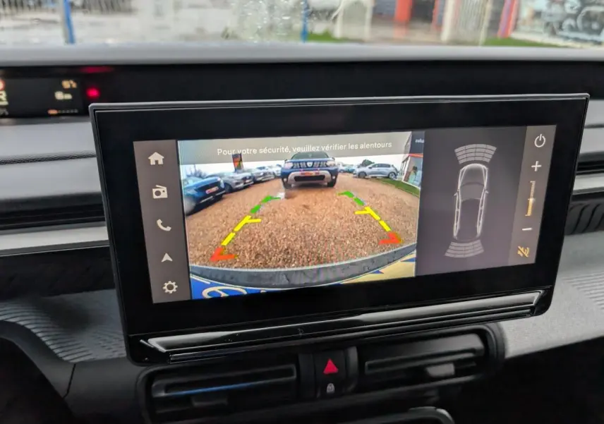 Écran tactile intérieur montrant la caméra de recul avec vue arrière sur un parking, tableau de bord gris du Citroën C3 Aircross.