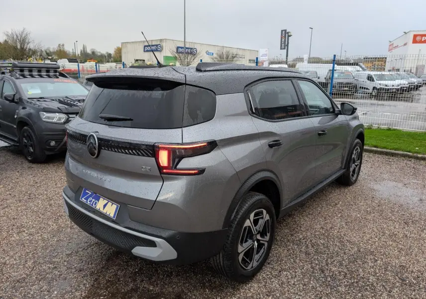 Vue 3/4 arrière droite d'une Citroën C3 Aircross 2025 gris métallisé avec toit noir et jantes alliage diamantées.