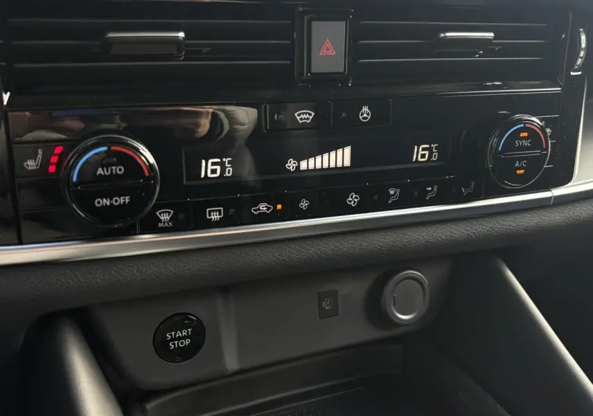 Gros plan sur la console centrale du Nissan Qashqai 2025, affichage numérique de la climatisation à 16°C et bouton Start/Stop.
