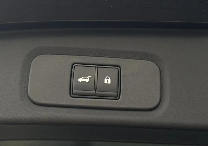 Gros plan sur les boutons d'ouverture électrique et de verrouillage du hayon du Nissan Qashqai noir 2025.