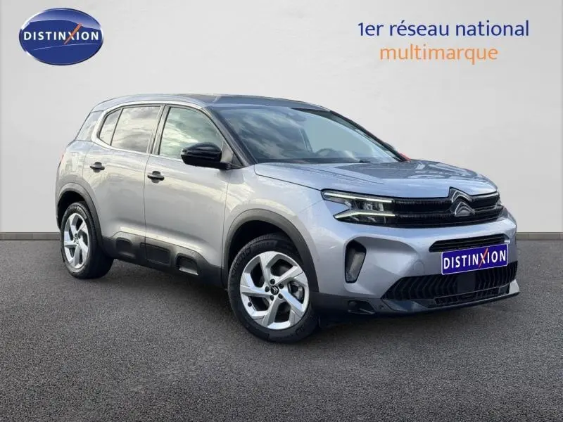 Vue 3/4 avant d'un Citroën C5 Aircross gris 2024 avec détails noirs contrastants et jantes alliage.