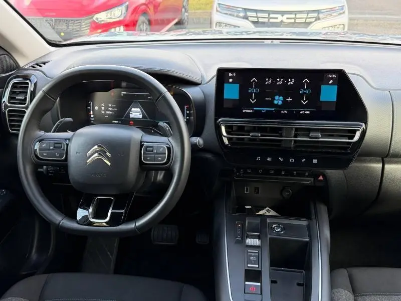 Vue intérieure du tableau de bord et volant du Citroën C5 Aircross gris 2024 avec écran tactile et commandes au volant.