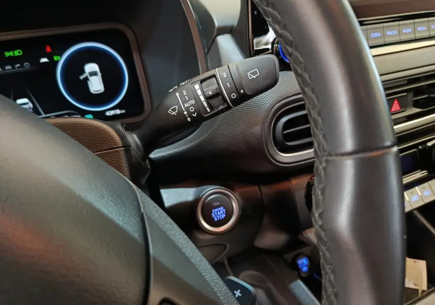 Vue intérieure rapprochée du volant cuir noir et du bouton démarrage du Hyundai Kona 1.6 Hybrid 2023.