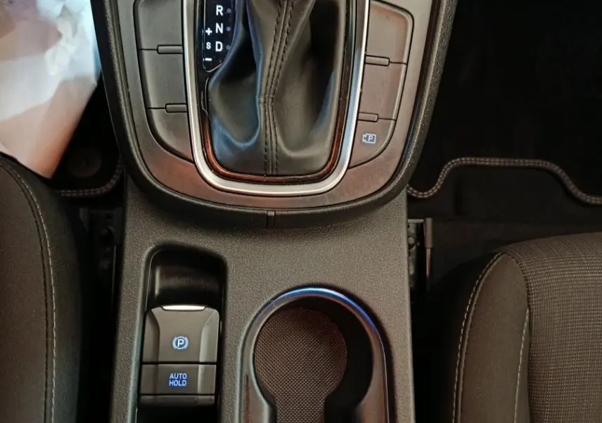 Vue plongeante sur la console centrale noire du Hyundai Kona 2023 avec levier de vitesse automatique et porte-gobelets.