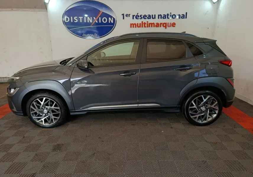 Vue de profil côté gauche d'un Hyundai Kona 1.6 Hybrid 141 Creative gris foncé avec jantes alliage et toit noir.
